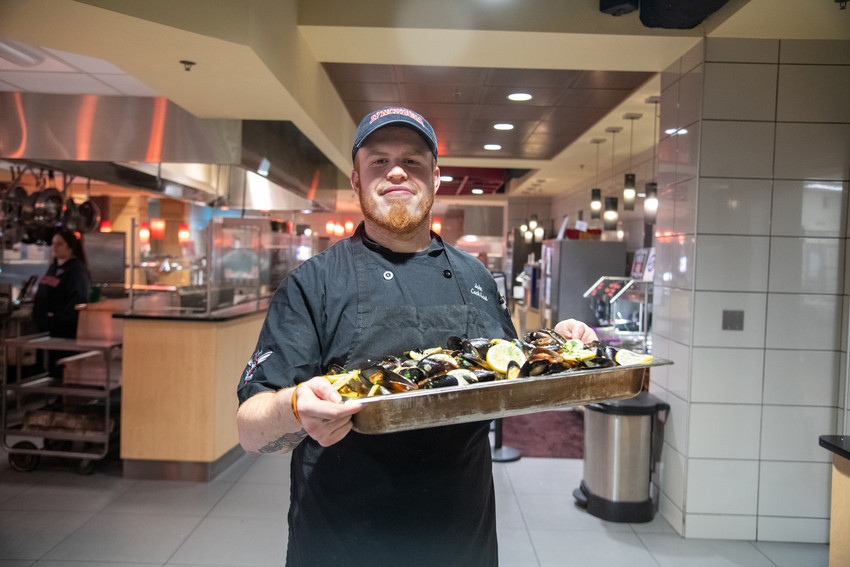 Man serving food and smiling.